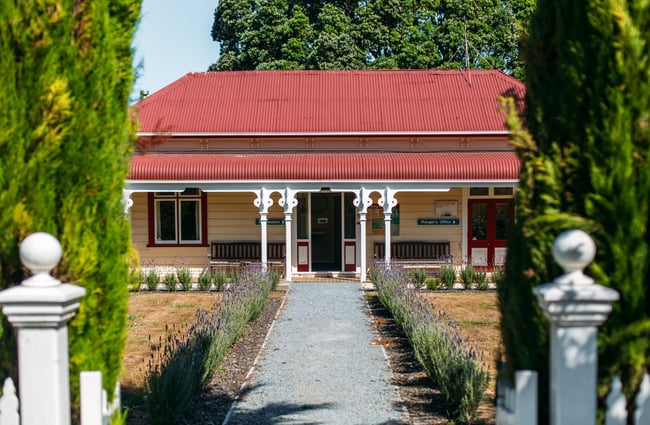 Cottage with red roof and central pathway.