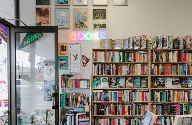 Entrance to Bay Hill Booksellers with neon sign on the wall at Bay Hills Books in Timaru, New Zealand.
