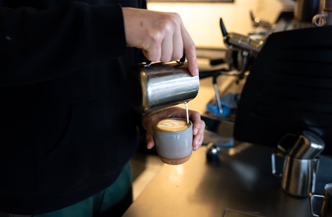A barista making a coffee.
