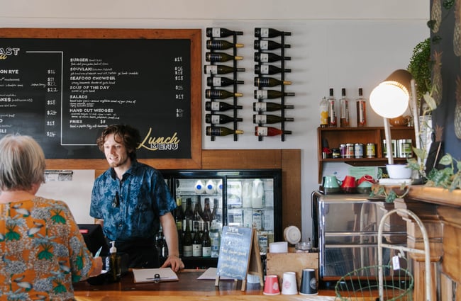 Man behind the counter serving a customer.