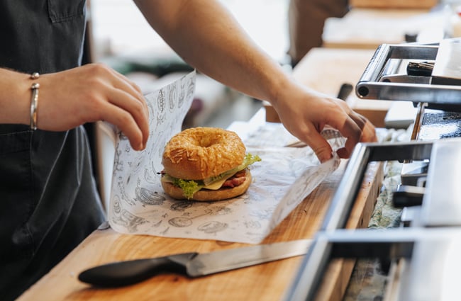A bagel being wrapped.