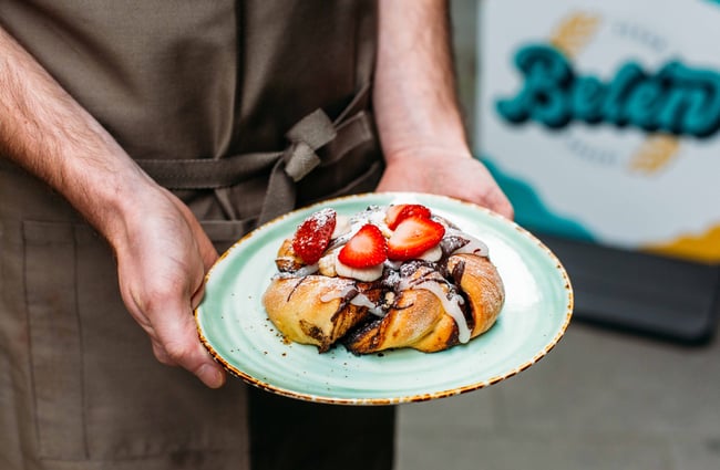 Person holding a vegan pastry with strawberries at Belén, Wellington.