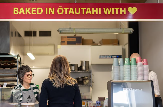 Customer ordering at the counter next to the coffee machine at Bellbird Bakery Holmwood.