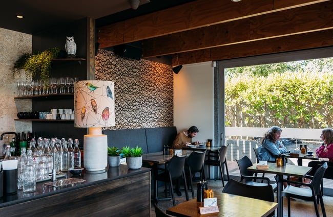 People dining inside an industrial-style cafe.