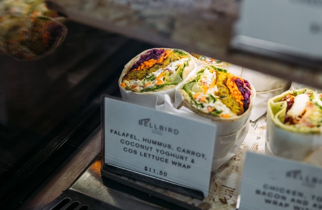 A close up of a falafel wrap in a glass cabinet.