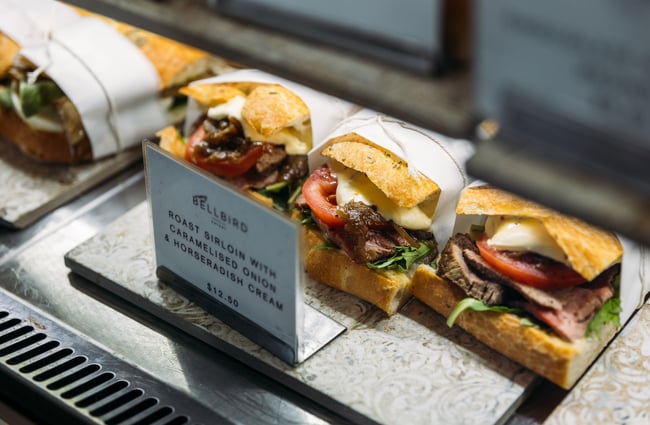 Filled ciabatta sandwiches in a cabinet.