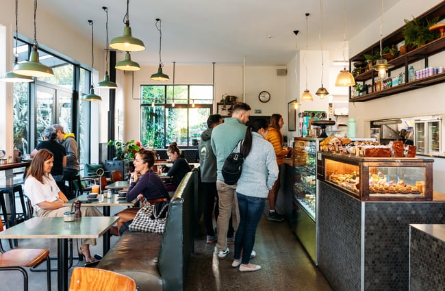 Customers waiting in line at a cafe counter.