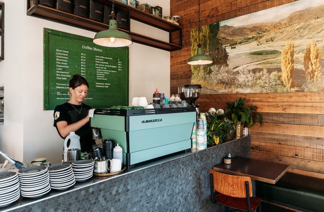 A barista making coffee in a cafe.