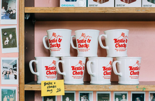 Bestie x Checks mugs on a shelf at Bestie.