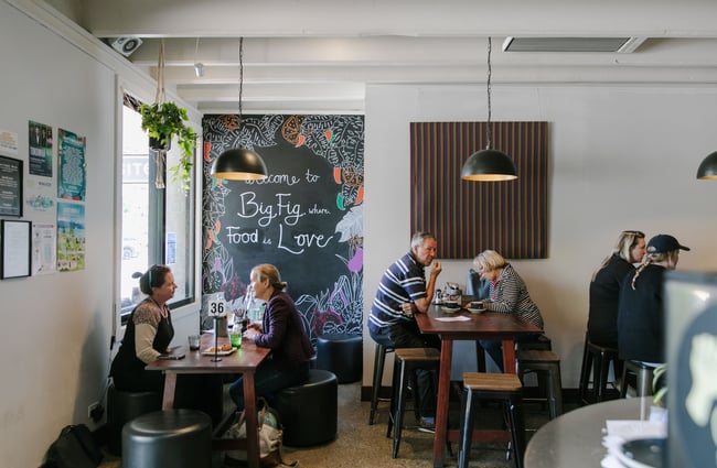 Customers sitting at tables and dining inside Big Fig cafe.