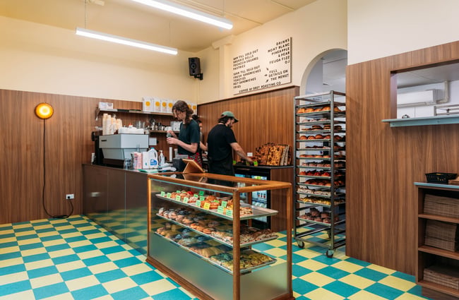 Cabinet of goods and baristas at the machine at Big Lizard.