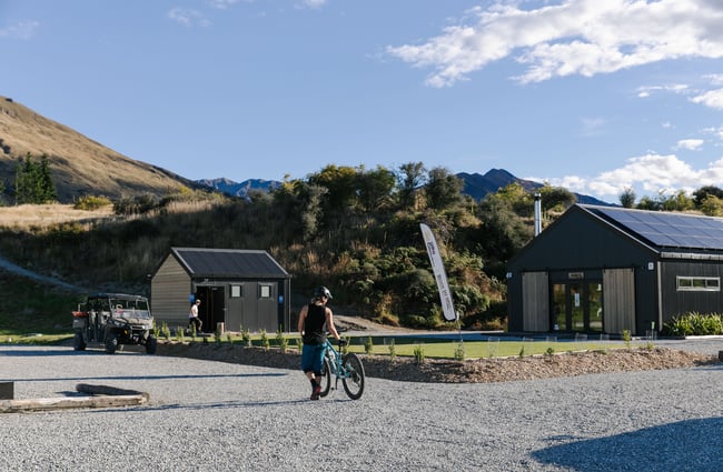 Woman pushing bike along.