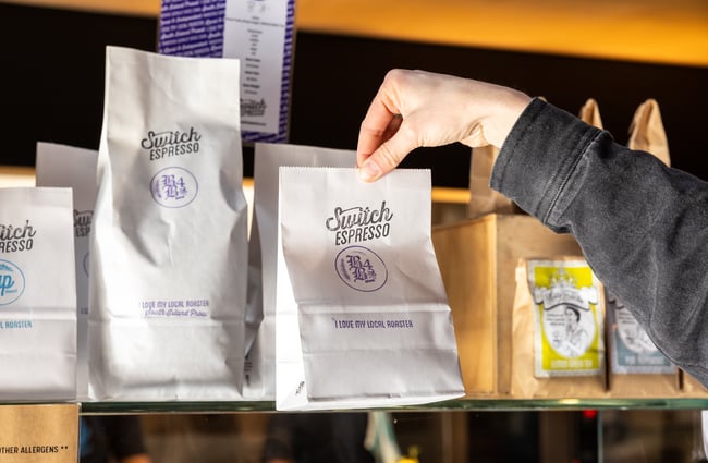 Customer selects a bag of coffee beans at Black Betty.
