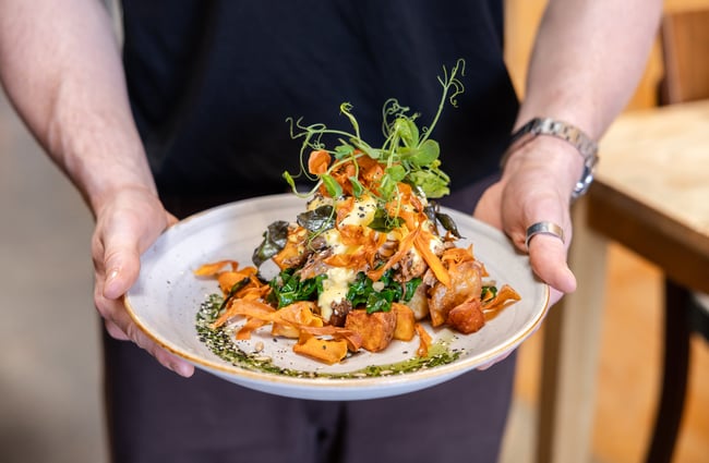 Wait staff carrying a plate of food at Black Betty.