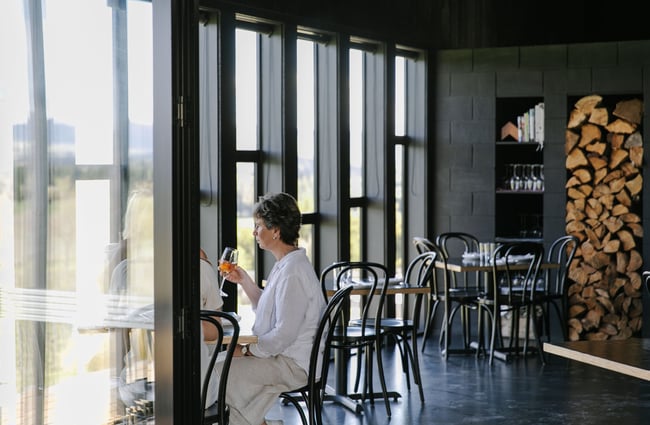 Woman about to drink glass of wine at Black Estate, North Canterbury.