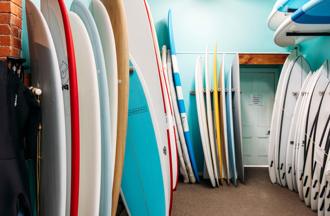 Surf boards lined up inside a retail store.