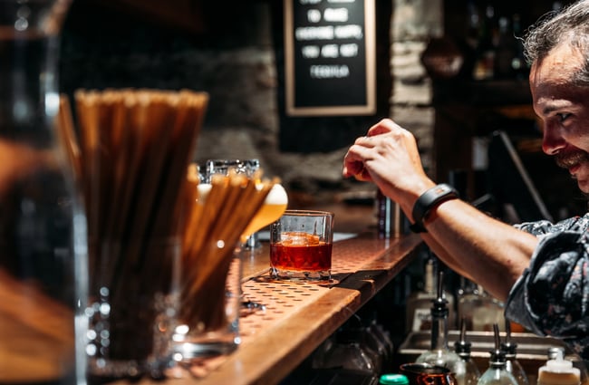 A man making a cocktail at a bar.