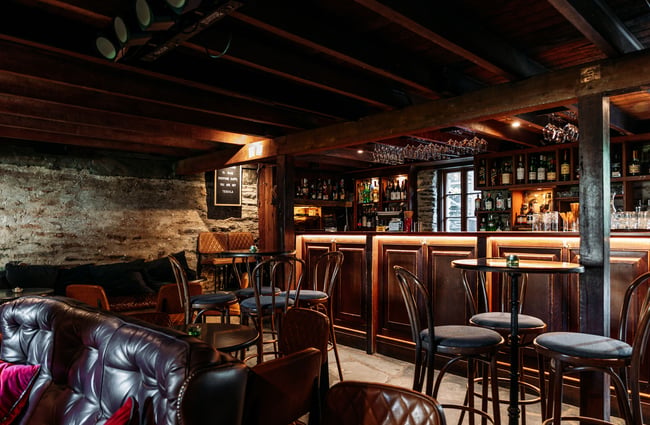 The seating area inside a darkly lit bar.