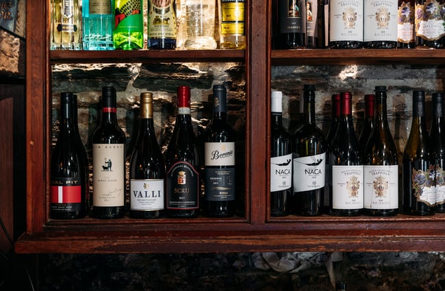 A close up of bottles of wine behind glass doors.