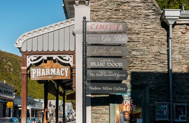 An old street sign pointing to The Blue Door bar.