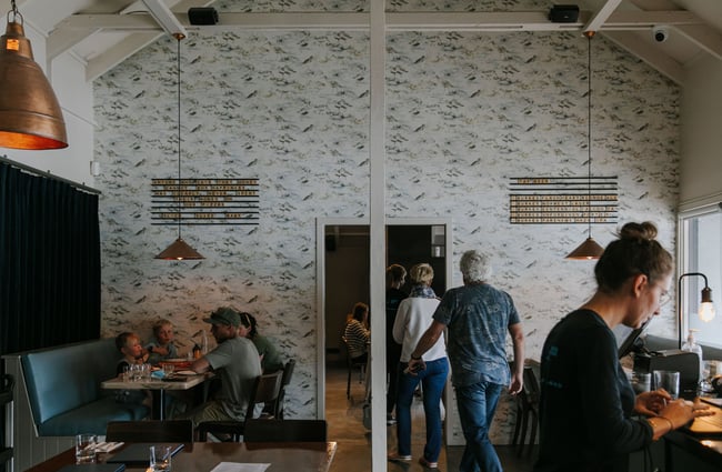 Customers dining and others walking into the bar area at Blue Lake Eatery and Bar, Tekapo.