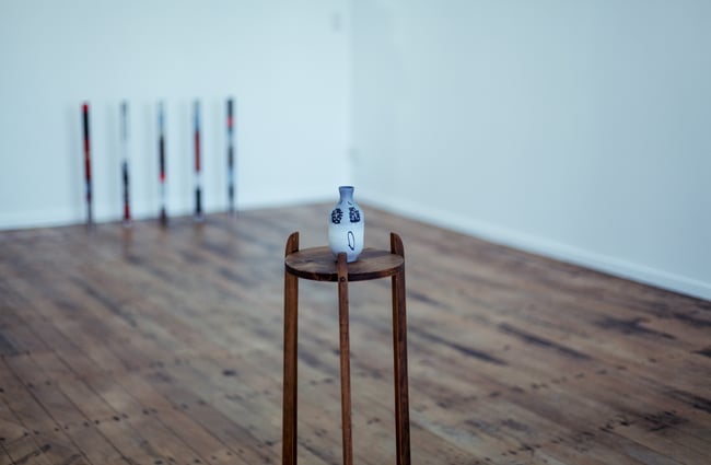 Urn on a stand on the wooden floor.