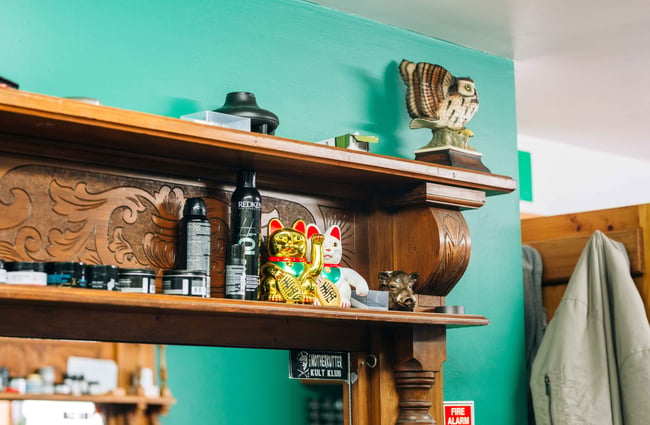Shelves of items on a wooden fireplace.
