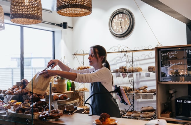 Woman piling pastries on trays at Bohemian Bakery in Christchurch's central city.