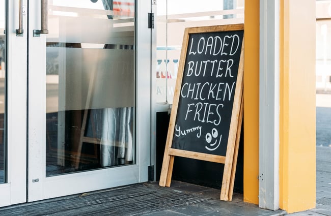 A sign that says 'Loaded butter chicken fries'.