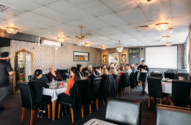 A long table full of people inside a restaurant.