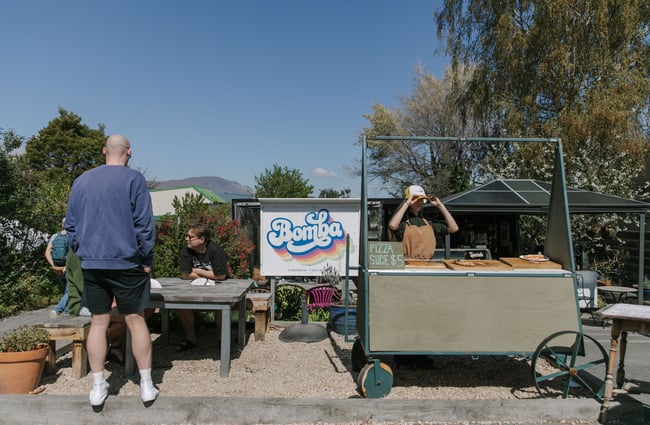 A little pizza cart on a sunny day.