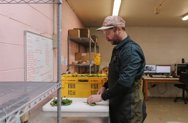 Chef preparing cucumbers for pickling at Bones Pickles.