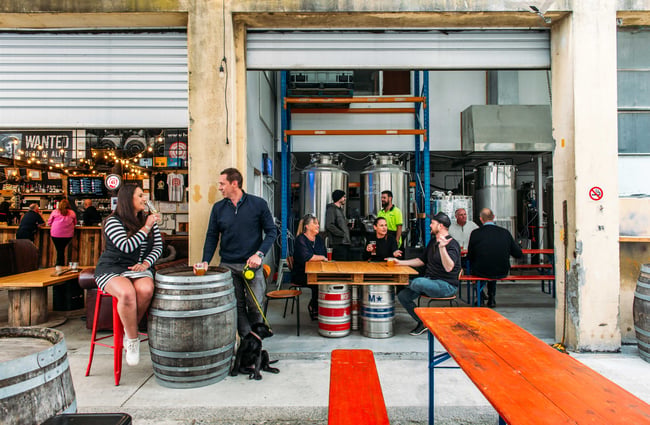 Outside the brewery in the courtyard with old barrels as tables.