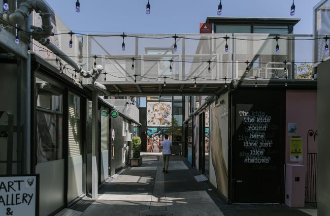 Looking down a laneway with bulb lighting strung overhead in BOXed Quarter in Christchurch.