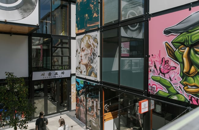 Large artworks up the walls of the open-air internal courtyard at BOXed Quarter in Christchurch.