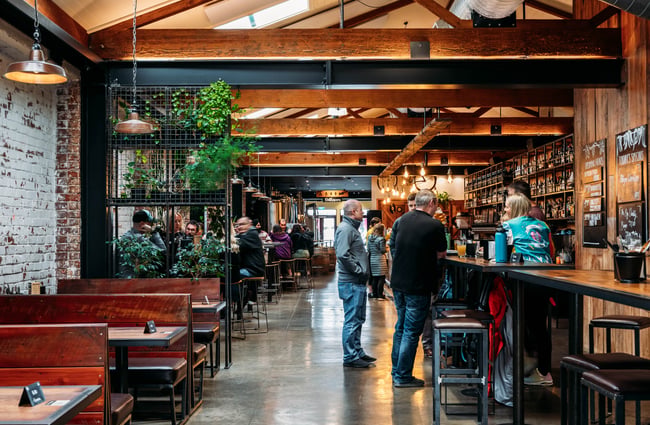 Customers standing at the bar area and other customers sitting at tables at Brew Union.