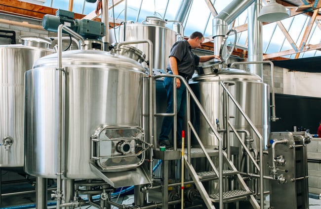 Brewer checks the beer at Brewaucracy, Hamilton.
