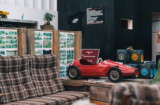 Red car by brown couch.
