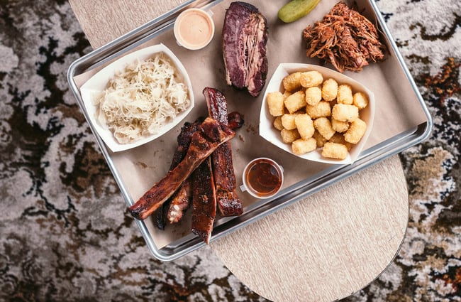 Food on a table above a vintage carpet.