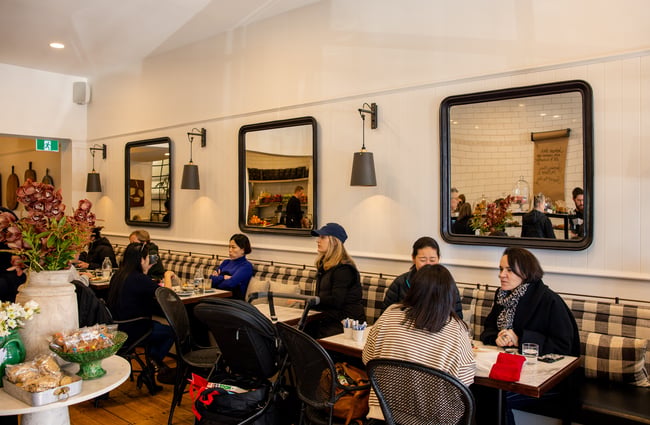 Customers sitting at tables inside a busy cafe.