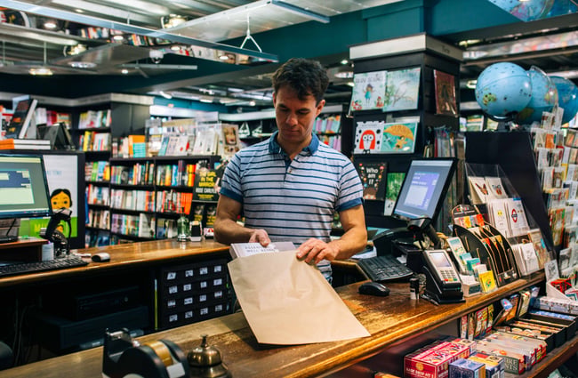 A staff member booking a book in a bag.