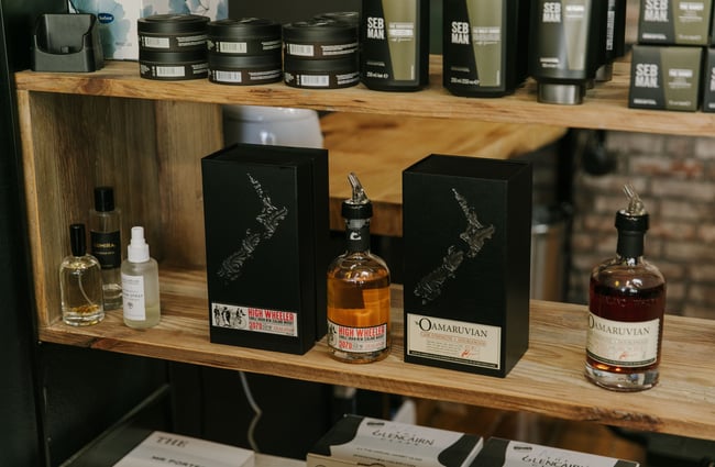 A close up of whisky bottles on a wooden shelf.