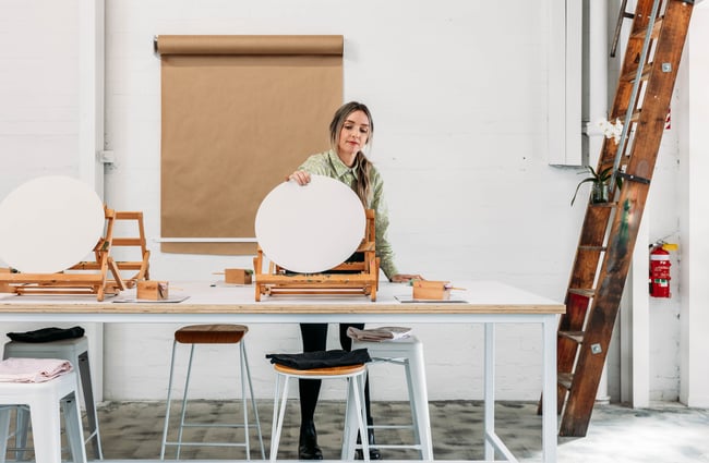 A woman holding a blank canvas.