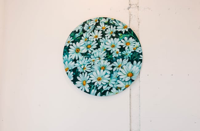 A round flower work of art on a wall.