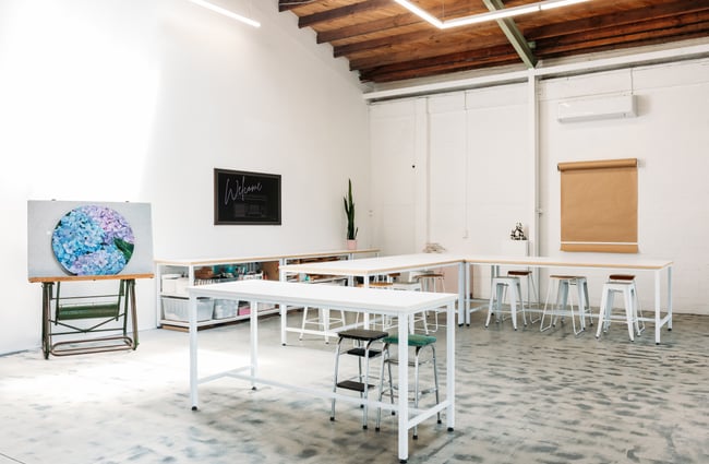White trestle tables inside an art gallery.