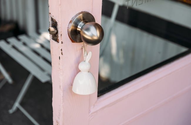 A white bunny hanging from a door.