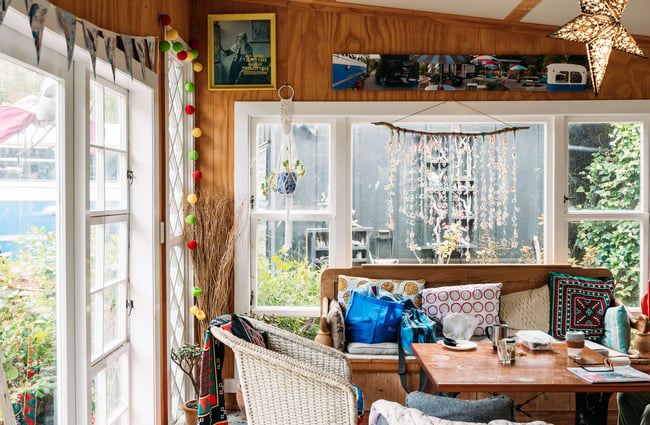 A vintage living room sitting next to large windows.