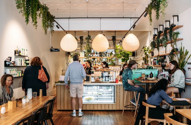 Customers sitting at tables and waiting to be served inside the cafe.