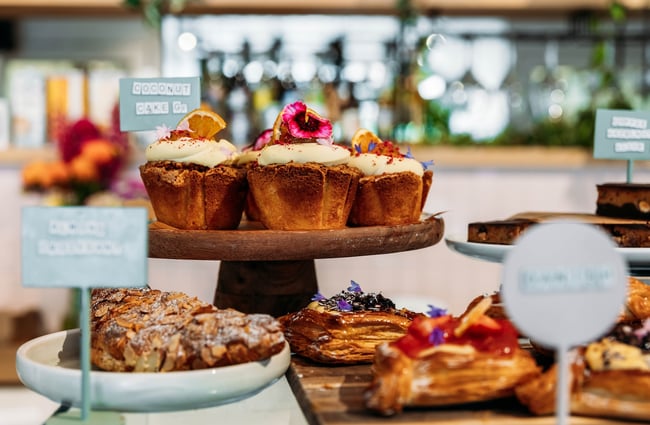 Close up of cakes, croissants and other pastries on display.