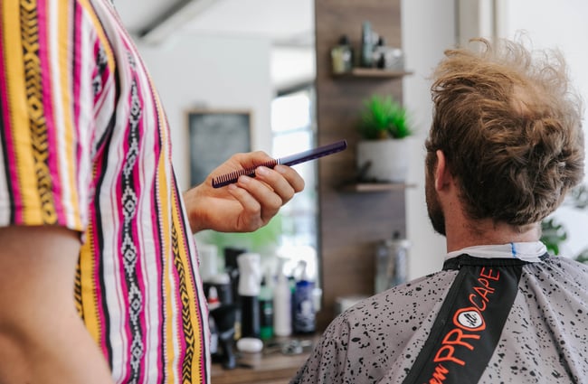 Barber holding a comb.
